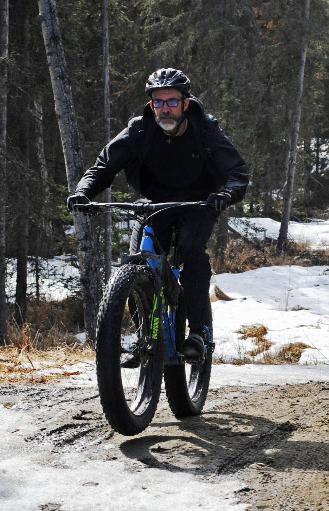 Dave Edwards-Smith powers his fatbike up a hill on the Porcupine Trail during the 2018 &ldquo;Choose Your Weapon&rdquo; race at Tsalteshi Trails on Sunday, April 15, 2018 in Soldotna, Alaska. Racers completed two 5-kilometer laps around the lower trails by running, biking or skiing, with the option of switching between laps for extra points. Most of the trails had some snow with patches of wet mud sprinkled throughout as spring temperatures begin to dominate the central Kenai Peninsula. (Photo by Elizabeth Earl/Peninsula Clarion)