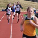 Kenai Central teammates Jaycie Calvert (left) and Brooke Satathite trail race leader Ruby Lindquist of Seward in the girls 1,600 meters Saturday afternoon at Homer High School. (Photo by Joey Klecka/Peninsula Clarion)