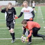 Nikiski goalkeeper Abby Bystedt makes a save in front of Nikiski&rsquo;s Aspen Hooper and Kenai Central&rsquo;s Liz Hanson on Monday, April 23, 2018, at Kenai Central High School. (Photo by Jeff Helminiak/Peninsula Clarion)