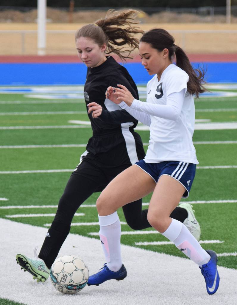 Nikiski&rsquo;s America Jeffreys (left) and Soldotna&rsquo;s Faith Glassmaker battle for the ball Tuesday evening at Soldotna High School. (Photo by Joey Klecka/Peninsula Clarion)