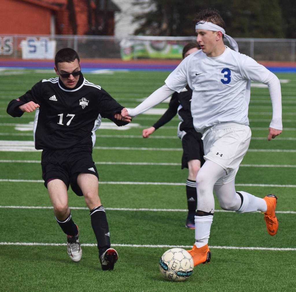 Nikiski&rsquo;s Joe Yourkoski (17) engages Soldotna&rsquo;s Luke Trammell in a fight for the ball Tuesday evening at Soldotna High School. (Photo by Joey Klecka/Peninsula Clarion)