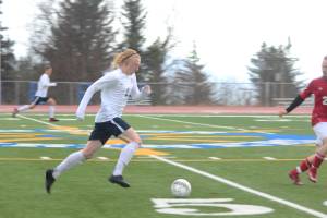 Homer senior Charles Rohr charges down the field with the ball during Homer High School&rsquo;s game against Kenai Central High School on Tuesday, April 24, 2018 in Homer, Alaska. The Kardinals beat the Mariners 6-2. (Photo by Megan Pacer/Homer News)