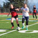 Homer&rsquo;s Brenna McCarron battles with Kenai&rsquo;s Julia Hanson to reach the ball first during their game Tuesday, April 24, 2018 in Homer, Alaska. The Mariners beat the Kardinals 1-0. (Photo by Megan Pacer/Homer News)