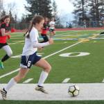 Homer&rsquo;s Eve Brau takes the ball up the field pursued by Kenai High School&rsquo;s Abigail Every during their game against Tuesday, April 24, 2018 in Homer, Alaska. (Photo by Megan Pacer/Homer News)