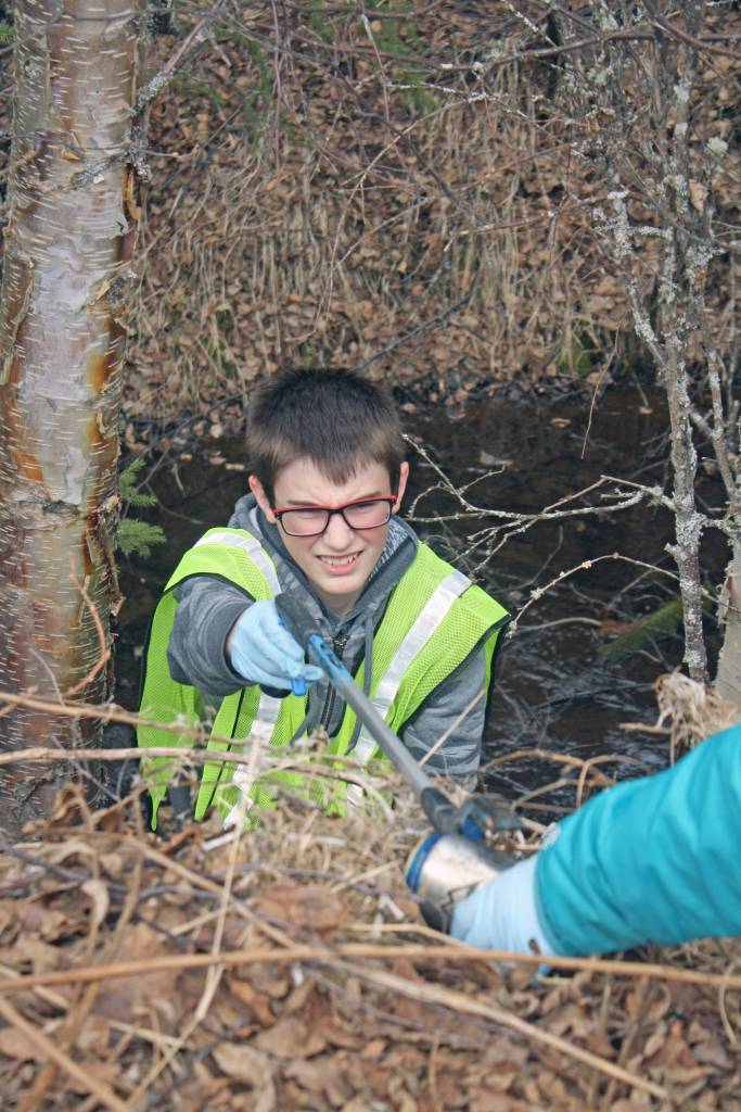 Girl Scouts Caitlyn Crapps, left, and Kadie Newkirk, discard a plastic glove during Kenai National Wildlife Refuge&rsquo;s Green Up, Clean Up event on Wednesday, May 2, 2018. (Photo by Erin Thompson/Peninsula Clarion)
