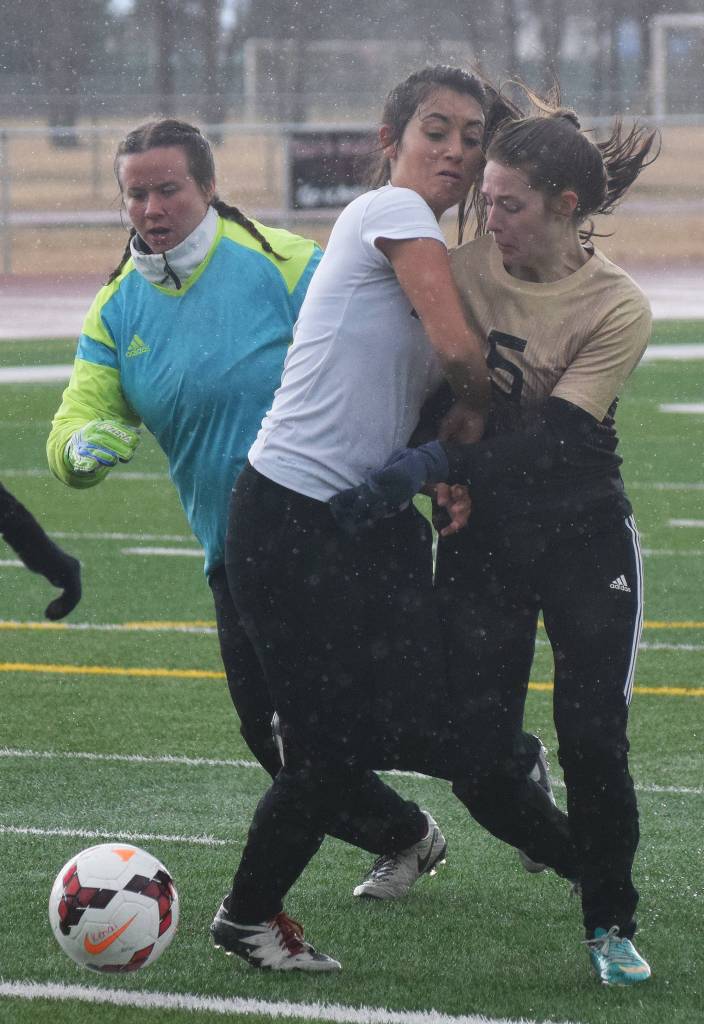 Kenai&rsquo;s Brenna Eubank (middle) battles with the Grace Christian goalkeeper and defender Amy Hatter (5) Saturday at Kenai Central High School. (Photo by Joey Klecka/Peninsula Clarion)
