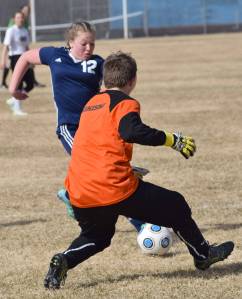 Soldotna&rsquo;s Mykenna Foster and Nikiski goalie Abby Bystedt race to the ball Monday, May 7, 2018, at Nikiski High School. (Photo by jeff Helminiak/Peninsula Clarion)