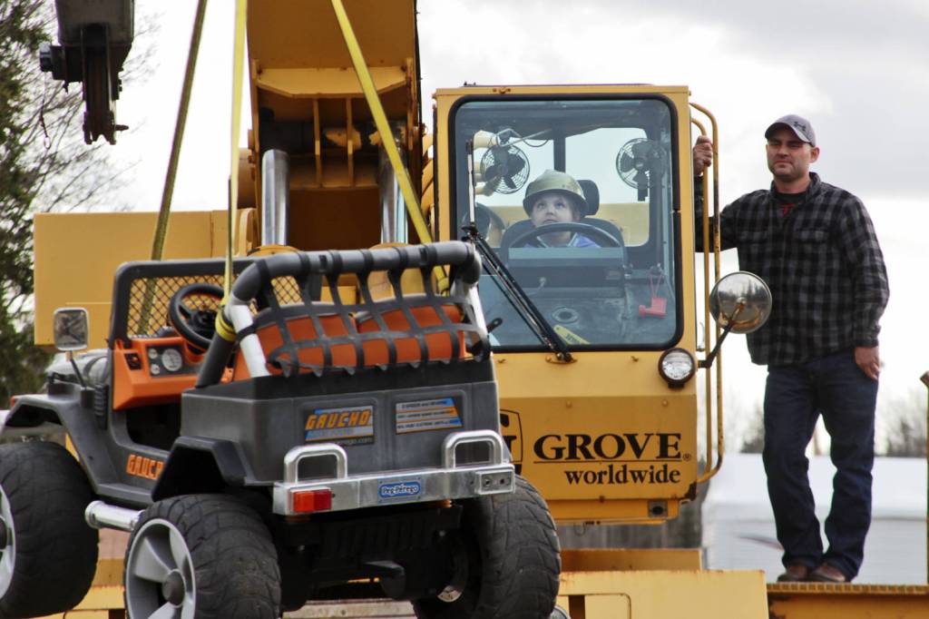 Madison Hibpshman (left) uses a crane to lift a toy electric jeep, watched by Mike Elmore, during her class&rsquo;s field trip to Alaska Crane Consultants on Monday, May 7, 2018 on Kalifornsky Beach road. (Ben Boettger/Peninsula Clarion)