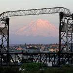 In this May 7, 2018 photo, Mount Rainier is seen at dusk and framed by the Murray Morgan Bridge in downtown Tacoma, Wash. The eruption of the Kilauea volcano in Hawaii has geologic experts along the West Coast warily eyeing the volcanic peaks in Washington, Oregon and California, including Rainier, that are part of the Pacific Ocean&rsquo;s ring of fire. (AP Photo/Ted S. Warren)