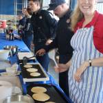 Claudia Browning flips the flap jacks during community dedication open house.