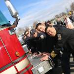 Chief Browning and first responders push a new ladder truck into its bay to officially dedicate it to service.