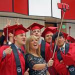Graduates take advantage of a selfie stick ahead of the the 2018 Kenai Central High School graduation on Monday. (Photo by Erin Thompson/Peninsula Clarion)