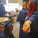 Kenai Alternative High School graduate Jessie Metz (left) zips up graduate Laura Archuleta&rsquo;s (right) graudation gown before the high school&rsquo;s graduation ceremony on Tuesday, May 22, 2018 in Kenai, Alaska. Kenai Alternative High School provides more flexible edcuation for students who struggled in traditional high school environments, scheduling classes around jobs, children and life circumstances to help students achieve their high school diplomas. (Photo by Elizabeth Earl/Peninsula Clarion)