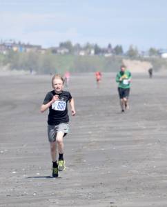 Jack Laker finishes off his victory in the three-mile run at the Mouth to Mouth Wild Run and Ride on Monday at the Kenai beach. (Photo by Jeff Helminiak/Peninsula Clarion)