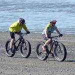 Catriona Reynolds finishes off a victory in the 10-mile bike at the Mouth to Mouth Wild Run and Ride on Monday at the Kenai beach. On Reynolds&rsquo; tail is Sky Carver. (Photo by Jeff Helminiak/Peninsula Clarion)