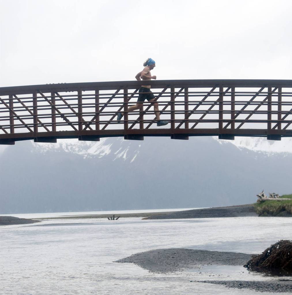 Pyper Dixon crosses a bridge during the Dixon/Holden Memorial Tonsina Beach Trail Run on Wednesday in Seward. (Photo by Jeff Helminiak/Peninsula Clarion)