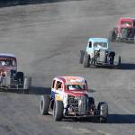 Bryan Barber leads a pack of Legend cars, including David Kusmider (second), Ty Torkelson (third) and Robert Spokes, Saturday night at Twin City Raceway in Kenai. (Photo by Joey Klecka/Peninsula Clarion)