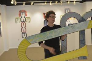 Susan Share dismantles &ldquo;Trellis Wardrobe&rdquo; at the Kenai Fine Arts Center on Monday in Kenai. The piece is the largest sculpture in her upcoming exhibition &ldquo;InFormal Nature.&rdquo; The sculpture is made entirely of paper, with the exception of many magnets that are used to hold the piece together, and allow the work to open and shut like a closet. (Photo by Victoria Petersen/Peninsula Clarion)