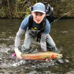 Nick Whicker poses on May 10, 2018 with his first steelhead, caught on the Situk River in Yakutat with a UAS Outdoors studies class taught by professor and Salmon Fellow Kevin Maier. The fish bit onto a fly Whicker had tied that morning (it already had a hook in its tail.) Photo by Triston Chaney
