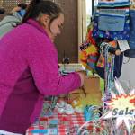Vanessa Lopez of Nikiski arranges necklaces on a rack at the stall for The Studio at the Kenai Saturday Market on Saturday, June 9, 2018 in Kenai, Alaska. The Kenai Chamber of Commerce coordinates the Saturday markets for farmers and craftspeople on the lawn at the Kenai Visitors and Cultural Center every Saturday during the summer. (Photo by Elizabeth Earl/Peninsula Clarion)