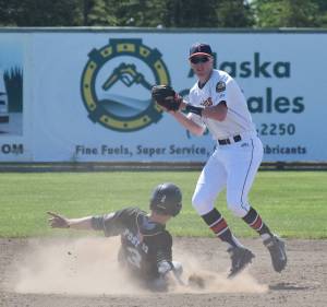 Kenai Twins shortstop Austin Asp attempts to relay a double play ball to first base while Chugiak&rsquo;s D.J. Davis slides into second Wednesday afternoon at Coral Seymour Memorial Ballpark. (Photo by Joey Klecka/Peninsula Clarion)