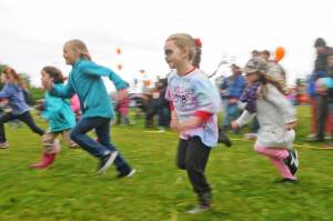 Brystol Flynn, 5, makes a dash for the finish line during a kids&rsquo; footrace at the North Peninsula Recreation Service Area&rsquo;s Family Fun in the Midnight Sun event Saturday, June 16, 2018 in Nikiski, Alaska. The annual event features a variety of booths and activities, including a candy hunt and footraces, martial arts demonstrations, food trucks, raffles and a chance to spray a fire hose courtesy of the Nikiski Fire Department. Though the morning started out chilly and rainy, the rain stopped by early afternoon for awhile. (Photo by Elizabeth Earl/Peninsula Clarion)
