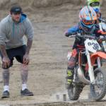 Shane Mullican, of Soldotna, watches as his son, Draiden roars off the starting line in the 65cc Novice race Sunday, June 17, 2018, at the Alaska State Motocross Championships at Twin City Raceway. (Photo by Jeff Helminiak/Peninsula Clarion)
