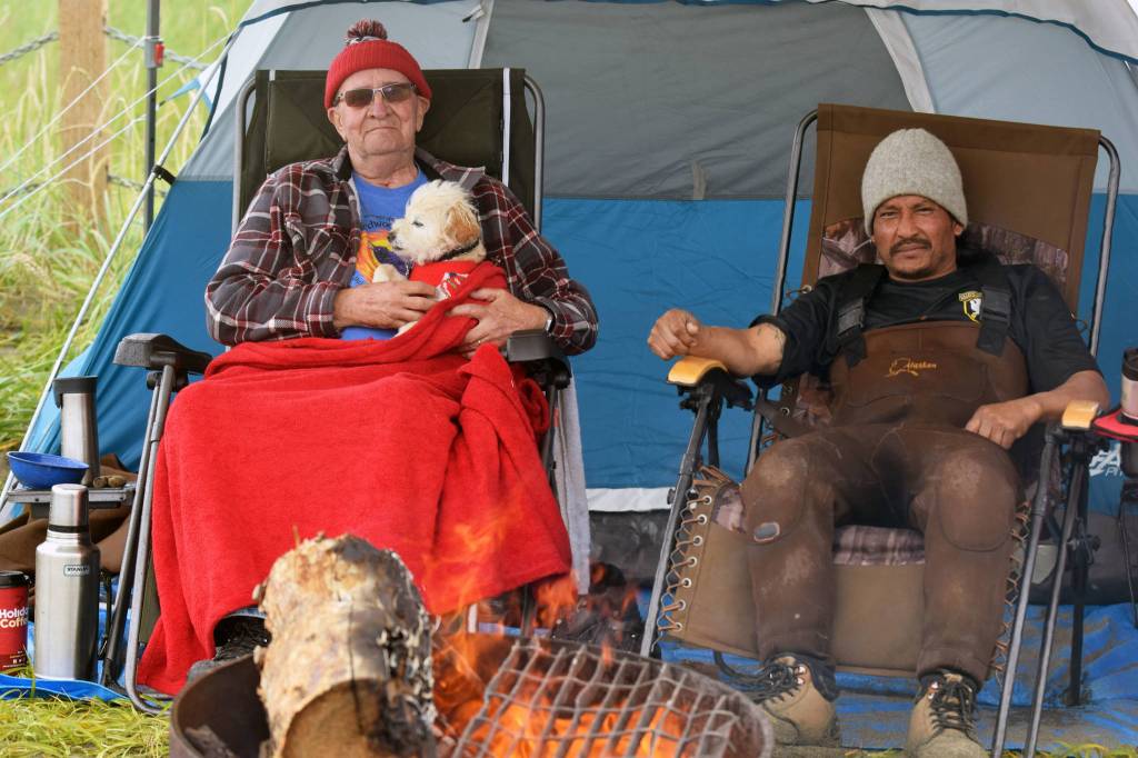 Anchorage residents Herb Morgan, left, and Tek Kniaziowski take a break on the beach on opening day of the three-week dipnetting season in Kenai, Alaska. The two, who were camping on the beach, travel to the peninsula annually to participate in the fish harvest. Kniaziowski said the fishing was slow going so far &mdash; by mid-afternoon the two had caught six flounders, but no salmon. (Photo by Erin Thompson/Peninsula Clarion)