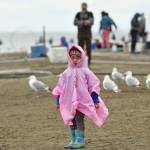 A young girl takes shelter from the rain on Tuesday, July 10, 2018, during the first day of dipnetting season in Kenai, Alaska. (Photo by Erin Thompson/Peninsula Clarion)