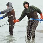Dipnetters stand in the shallows where the Kenai River meets Cook Inlet on Tuesday, July 10, 2018 in Kenai, Alaska.
