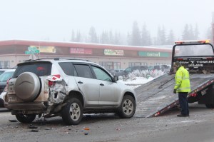 Members of Soldotna Y Towing Inc. prepare a vehicle to be taken away from the scene of a four-vehicle accident on Wednesday, Jan. 11, 2017 on the David Douthit Veterans Memorial Bridge in Soldotna, Alaska. One person was taken to the hospital with non-life threatening injuries. (Megan Pacer/Peninsula Clarion)