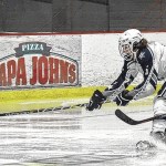 Palmer goalie Cody Grogan uses his pad to kick aside a shot by Soldotna&rsquo;s Matthew Daugherty while Palmer&rsquo;s Easton Armstrong defends Friday at the Soldotna Regional Sports Complex. (Photo by Jeff Helminiak/Peninsula Clarion)