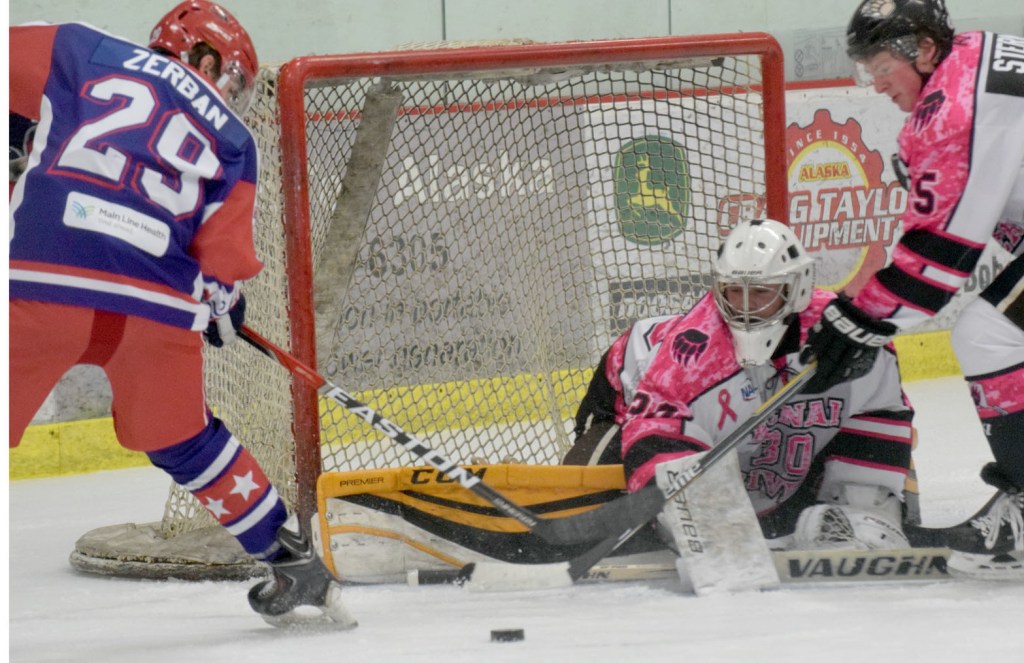 Kenai River goaltender Robbie Goor, with help from defenseman Sam Sterne, keeps Aston forward Jensen Zerban from scoring Friday at the Soldotna Regional Sports Complex. (Photo by Jeff Helminiak/Peninsula Clarion)
