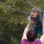 Mother and daughter enjoy the swings at the Soldotna Community playground.
