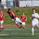 Kenai Central midfielder Kevin Ramos (center) sends the ball downfield in Friday's state soccer semifinal against Service at Service High School.