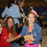 Soldotna Rotarians Jodi Stuart & Cathy Halligan give summer readers books & t-shirts at K-Beach RIGS assembly.