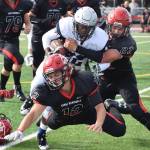 Eagle Rivers Kam Williams is wrapped up by Kenai defender Andrew Carver (82) Saturday at Ed Hollier Field in Kenai. (Photo by Joey Klecka/Peninsula Clarion)