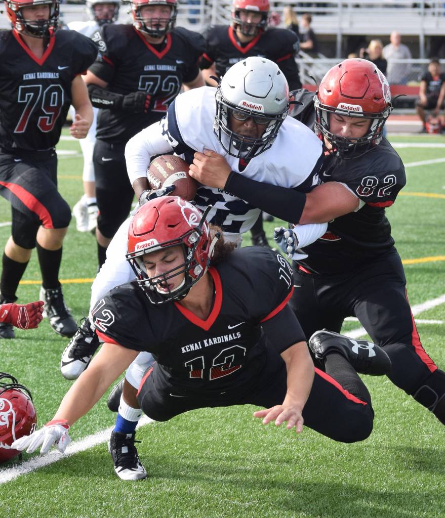 Eagle Rivers Kam Williams is wrapped up by Kenai defender Andrew Carver (82) Saturday at Ed Hollier Field in Kenai. (Photo by Joey Klecka/Peninsula Clarion)