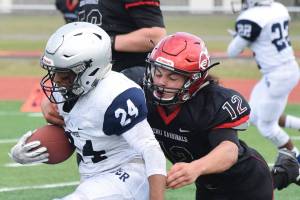Kenai defender Tyrone McEnerney tackles Eagle Rivers Kobe Sherman (24) Saturday at Ed Hollier Field in Kenai. (Photo by Joey Klecka/Peninsula Clarion)