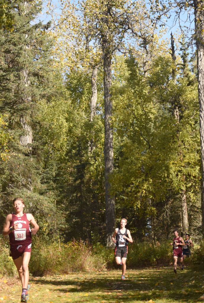 Grace Christians Gabe Martin leads Kenai Centrals Maison Dunham and the pack down a hill Saturday, Sept. 22, 2018, in the Division II race at the Region 3 meet at Tsalteshi Trails. (Photo by Jeff Helminiak/Peninsula Clarion)