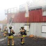 Firefighters respond to a controlled fire in a group of conexes off of Arc Loop Road in Soldotna. The area was set up to resemble a home and a fire was set in different sections of the building to test the firefighters. The training on Thursday was part of the Alaska Fire Conference which is being held in Kenai this week. (Photo by Kat Sorensen/Peninsula Clarion)