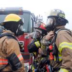 <strong>ABOVE: </strong>Firefighters prepare for a training session off Arc Loop Road on Thursday as part of the Alaska Fire Conference.                                 <strong>BELOW: </strong>Firefighters respond to a controlled fire in a group of conexes off of Arc Loop Road in Soldotna. The area was set up to resemble a home and a fire was set in different sections of the building to test the firefighters. The training on Thursday was part of the Alaska Fire Conference which is being held in Kenai this week. (Photo by Kat Sorensen/Peninsula Clarion)
