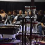 A crowd of statewide fire station employees enjoy a stand of dessert glasses and the festivities Friday night at the Alaska Fire Conference in the Kenai Center mall. (Photo by Joey Klecka/Peninsula Clarion)