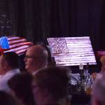 A pair of American flag design wall plaques sit on stage Friday night at the Alaska Fire Conference in the Kenai Center mall. (Photo by Joey Klecka/Peninsula Clarion)