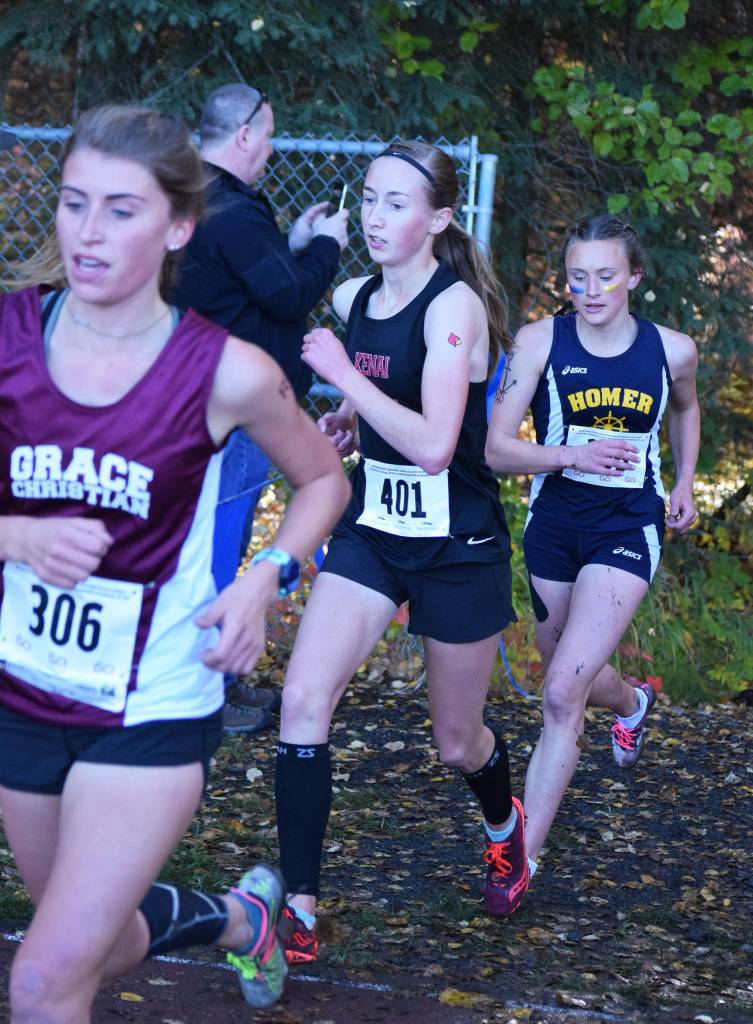 Grace Christians Mazzy Jackson (306), Kenai Central senior Jaycie Calvert (401) and Homer junior Autumn Daigle (right) run with the lead pack Saturday in the girls Division II race at the ASAA state cross-country running championships at the Bartlett Trails in Anchorage. (Photo by Joey Klecka/Peninsula Clarion)