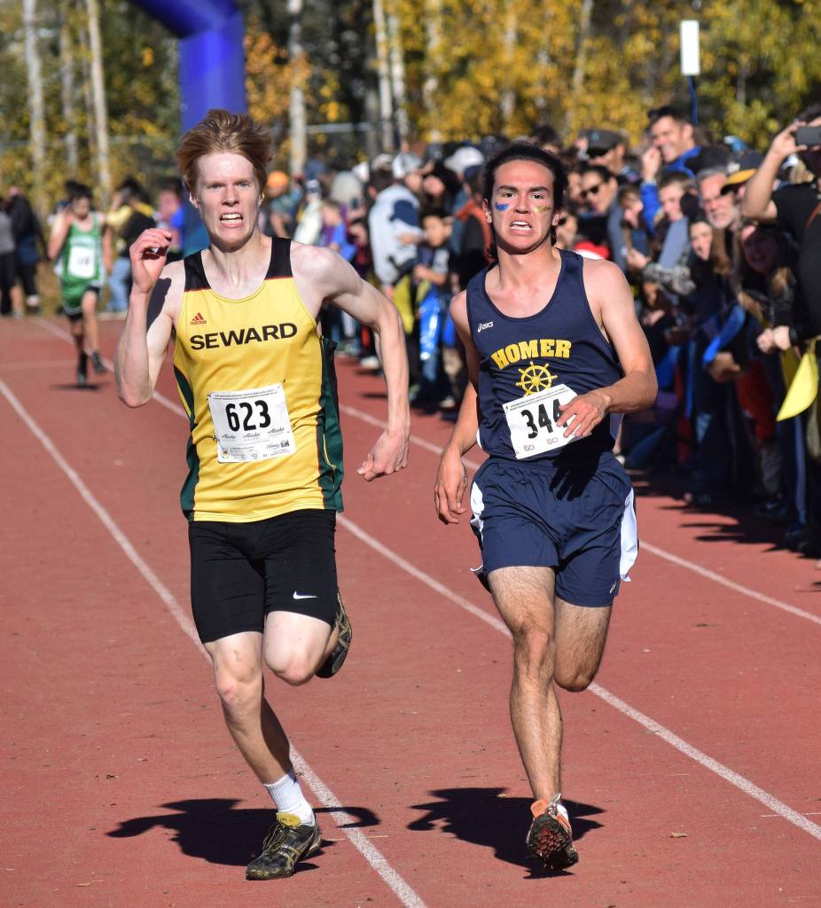 Sewards Max Pfeiffenberger (left) and Homers Bill Rich race for 16th place in the Division II boys race Saturday at the ASAA state cross-country running championships at the Bartlett Trails in Anchorage. (Photo by Joey Klecka/Peninsula Clarion)