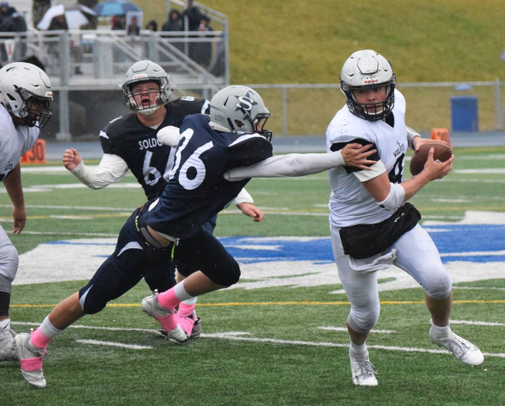 Eagle River quarterback Ryan Adkins attempts to escape the grasp of Soldotna lineman Zach Zeigler (36) Saturday in the Division II state football championship game at Machetanz Field in Palmer. (Photo by Joey Klecka/Peninsula Clarion)