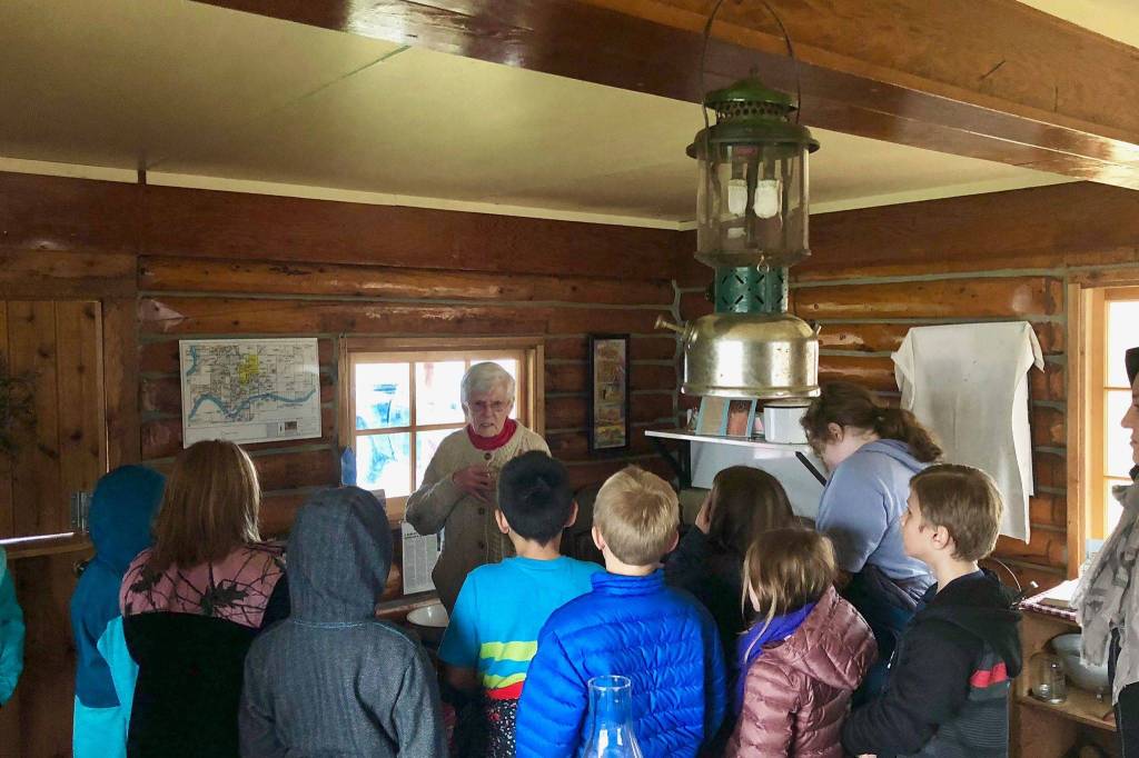 Marge Mullen shows a group of third graders around the Howard Lee Homestead, which was used as the citys first post office when she first homesteaded in Soldotna, on Wednesday, Oct. 17, 2018, in Soldotna, AK. (Photo by Victoria Petersen/Peninsula Clarion)