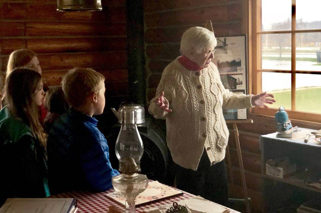 Marge Mullen shows a group of third graders around the Howard Lee Homestead, which was used as the citys first post office when she first homesteaded in Soldotna, on Wednesday, Oct. 17, 2018, in Soldotna, AK. (Photo by Victoria Petersen/Peninsula Clarion)