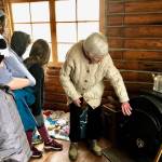 Marge Mullen shows a third-grade class how the residents of the Howard Lee Homestead heated their home, on Wednesday, Oct. 17, 2018, in Soldotna, AK. (Photo by Victoria Petersen/Peninsula Clarion)